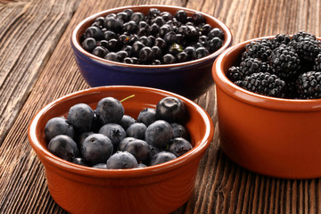 Fototapeta na wymiar Fresh blueberries and blackberries on old wooden background