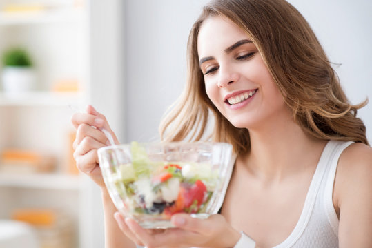 Nice joyful woman eating salad