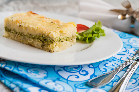 Potato Casserole With Spinach On A Plate And Cutlery