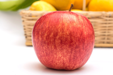 Close up of Fresh Apple with basket of mangoes in background