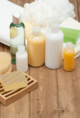 Fototapeta na wymiar Spa Kit. Shampoo, Soap Bar And Liquid. Shower Gel. Towels. Woode