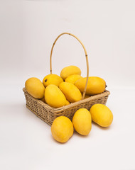 Fresh ripe chaunsa mangoes with basket on white