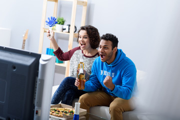 Man and woman watching tv on couch