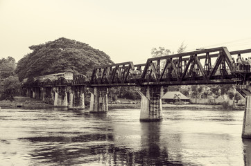 Black and white vintage photo style trains for travel running on the old bridge over the River Kwai is a historical attractions during World War 2 the famous of Kanchanaburi Province in Thailand