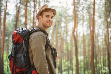 Joyful young man traveling in forest