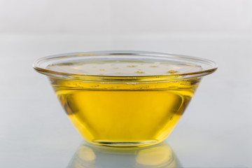 Olive oil in glass bowl on white