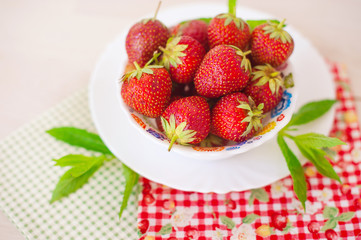 Fresh strawberry with min in white plate on cotton napkin