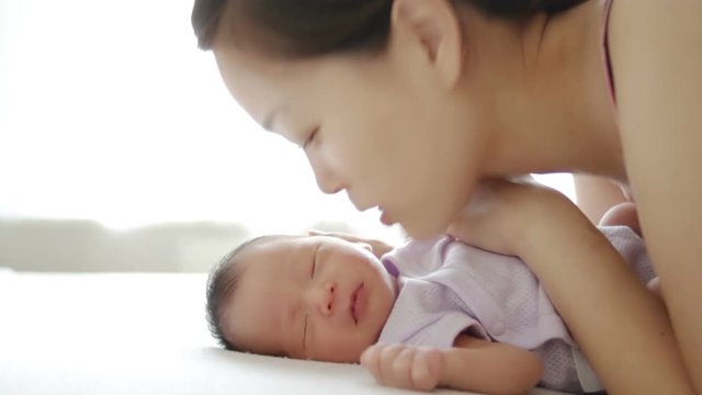 asian mother kisses baby on cheek, Japanese