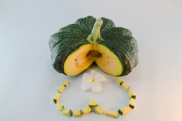Sliced raw yellow pumpkin heart symbo on white background.