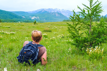 Naklejka na ściany i meble Woman backpacker resting and enjoying the view of nature 