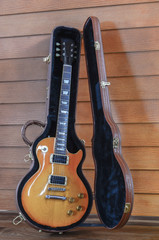 Electric Guitar and case in wood room