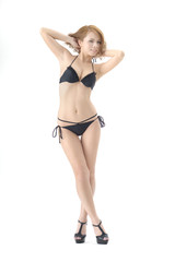 女性モデルが黒色のビキニの水着を着て立っています。スタジオで撮影された画像で、背景は白です。