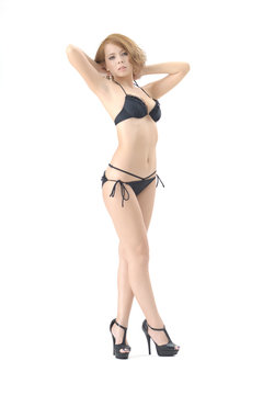 女性モデルが黒色のビキニの水着を着て立っています。スタジオで撮影された画像で、背景は白です。