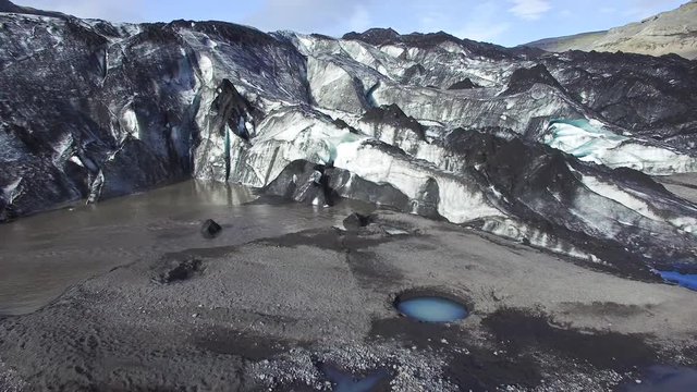 Aerial view of an outlet glacier in iceland in summer, melt water evident and great fissures