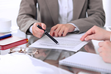 Group of business people and lawyers discussing contract papers sitting at the table, close up