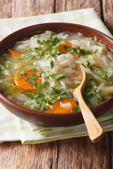 Cabbage soup with vegetables close up in a bowl. vertical
