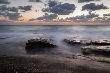 Long exposure creating dreamy water effect on the rocks after sunset, Nahariya Beach
