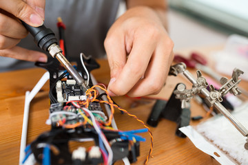 Man using welding for connecting wire on board of the drone