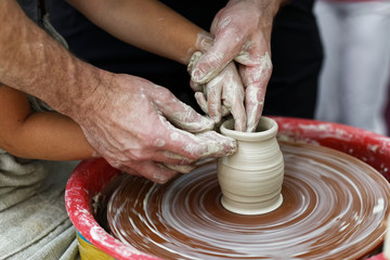 Hands of the potter and his young disciple