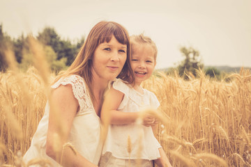 jolie maman et son enfant dans les champs de blé