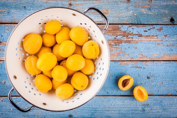 Fresh ripe organic apricots in colander  above view