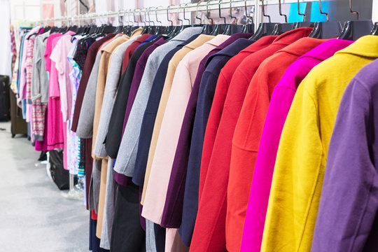 Multi-colored coat hanging on hangers.