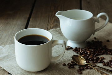 Cup of black coffee and milk jug