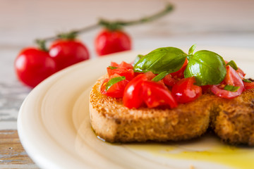 Fototapeta na wymiar Closeup of bruschetta with tomato and basil