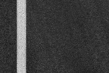 Level asphalted road with a dividing white stripes. The texture of the tarmac, top view.