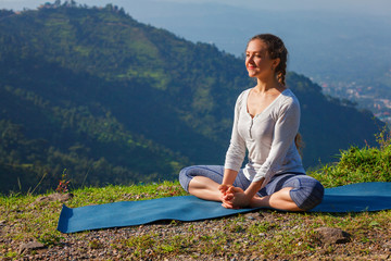 Naklejka na ściany i meble Sporty fit woman practices yoga asana Baddha Konasana outdoors