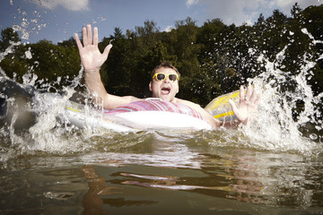 Funny man bathing in european lake in summer time