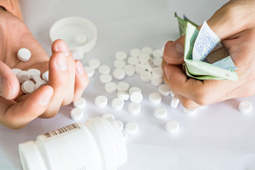 Hands holding analgesic medicine scattered with business financial crisis