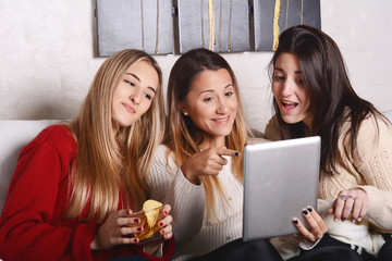 Three young friends having fun and using tablet.