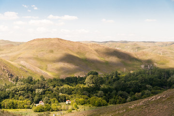 The shadow of clouds on the wooded rolling hills.