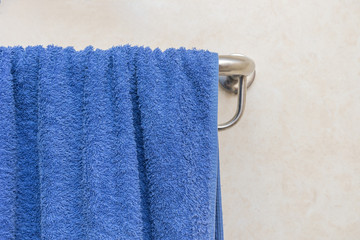 Blue towel hanging on the rail in bathroom