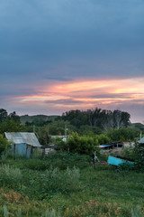Fototapeta na wymiar Bright sunset sky over a summer rural landscape