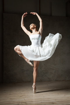 Fototapeta Beautiful ballerina dancing in white dress