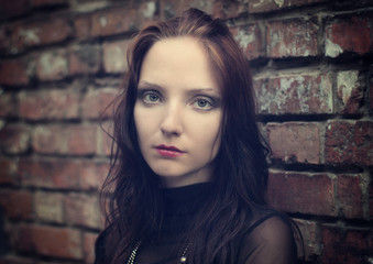 Fototapeta premium Girl at a brick wall