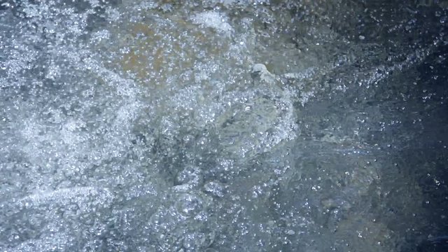 Video 1080p - Water is churning and frothing at the bottom of a waterfall. Bubbling and swirling are the visible results of the impact on the pool from the falling water. Background WITH SOUND
