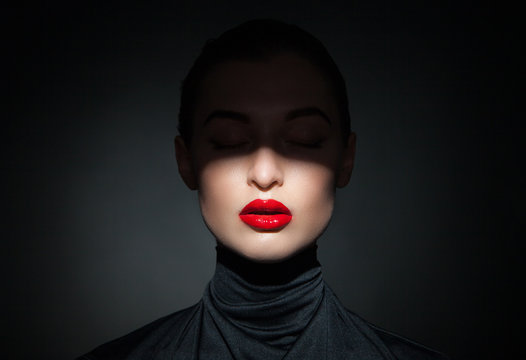 Beautiful Model With Bright Red Lips And Face Half Covered In Shadow