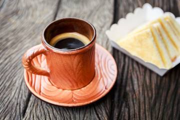 Hot black coffee on the wooden table, coffee break time with swe