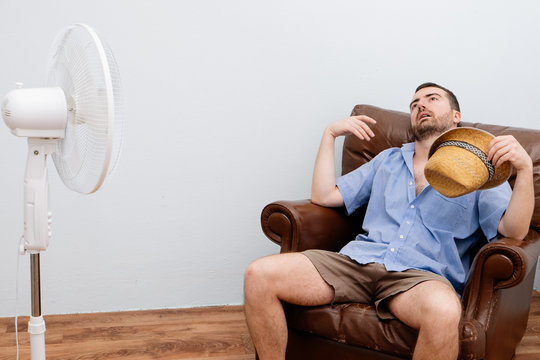 Flushed Man Feeling Hot In Front Of A Fan