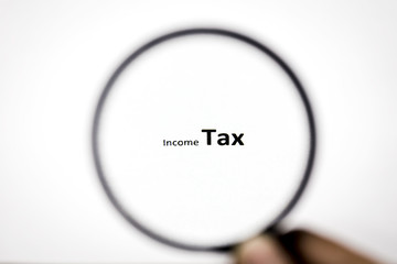 Looking Income Tax word through the magnifier