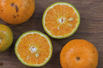 Orange, half of orange, orange lobule and basket with oranges on the wooden table
