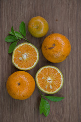 Orange, half of orange, orange lobule and basket with oranges on the wooden table