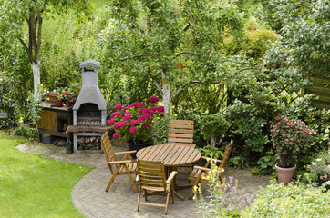 Tisch und Gartenkamin im Sommergarten