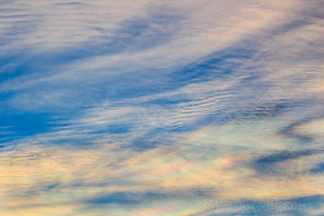 Colorful iridescent cloud, Beautiful Rainbow cloud. Blue sky at sunset, abstract background.