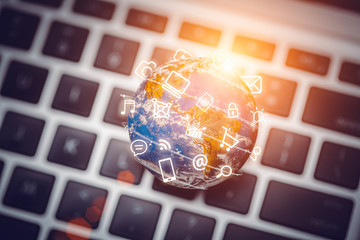 media icons fly around globe on laptop