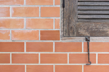 Fototapeta premium The part of old wooden window with the red brick wall