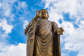 Giant golden buddha standing scenic in buddhist place at thipsukontharam temple, huai krachao, kanchanaburi, thailand